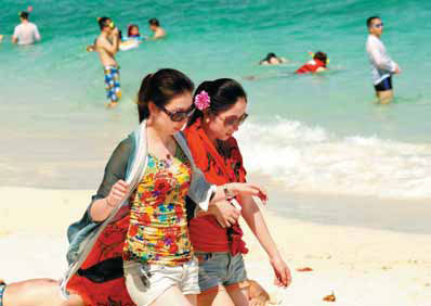 Two Chinese women walking on the beach in Phuket, Thailand. Many Chinese travelers chose to stay closer to home, choosing Asian destinations. Provided to China Daily Chinese spend less on hotels, still flash the cash