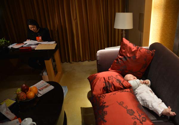 Luo Wei, a deputy to the 18th National Congress of the Communist Party of China, takes care of her five-month-old daughter at a hotel after finishing a group discussion in Beijing on Nov 10, 2012. Luo, who took her baby to Beijing as she is still breastfeeding, is the youngest deputy of Southwest China's Sichuan province delegation and donated 55 percent of her liver to save the life of an unrelated person in 2005. From congress delegate to caring mom