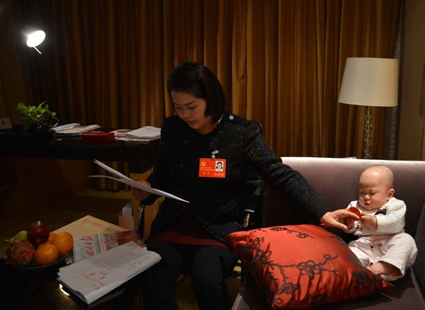 Luo Wei, a deputy to the 18th National Congress of the Communist Party of China, takes care of her five-month-old daughter at a hotel after finishing a group discussion in Beijing on Nov 10, 2012. Luo, who took her baby to Beijing as she is still breastfeeding, is the youngest deputy of Southwest China's Sichuan province delegation and donated 55 percent of her liver to save the life of an unrelated person in 2005. From congress delegate to caring mom