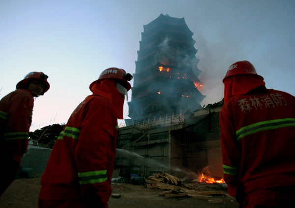 Firefighters battle a fire on Yongding Tower, one of the major buildings of the Ninth China (Beijing) International Garden Expo, on Monday. Wang Jing / China Daily Beijing's Garden Expo might be delayed after fire