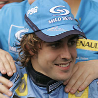 Renault's Formula One driver Fernando Alonso (C) of Spain celebrates with his team's mechanics after finishing third in the Brazil Grand Prix in Sao Paulo September 25, 2005.