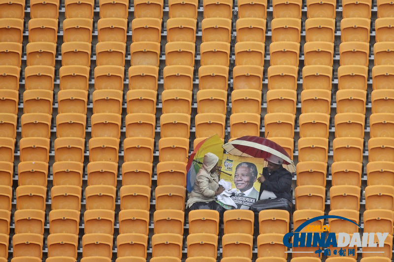 曼德拉追悼會(huì)現(xiàn)場:情侶為偉人海報(bào)打傘