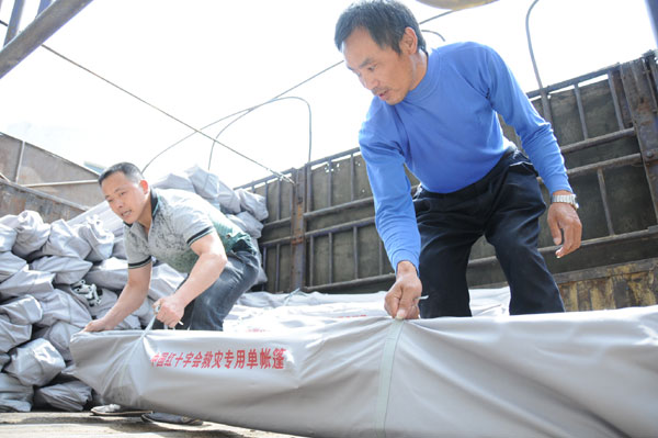 Workers prepare relief goods for quake victims at the Red Cross emergency supplies center in Nanchong city, Sichuan province, April 20, 2013. Relief materials dispatched to quake-hit areas