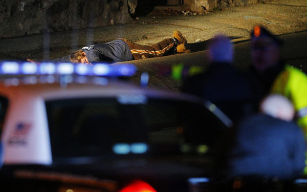 Police officers keep a man on the ground in Watertown, Massachusetts April 19, 2013 following the shooting of a police officer at the Massachusetts Institute of Technology (MIT). Police officer shot dead at MIT