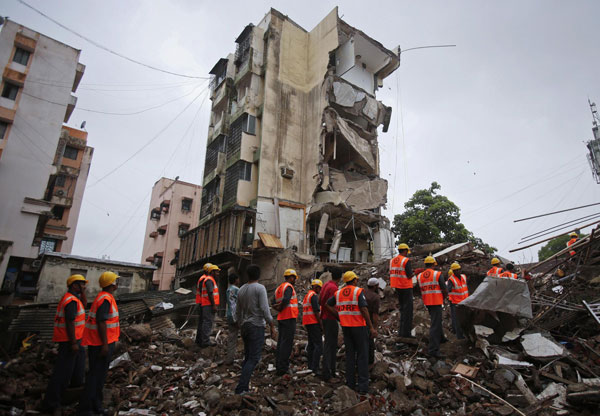 Rescue workers search through rubble at the site of a collapsed residential building in Mumbai early June 11, 2013. Mumbai building collapse kills 5